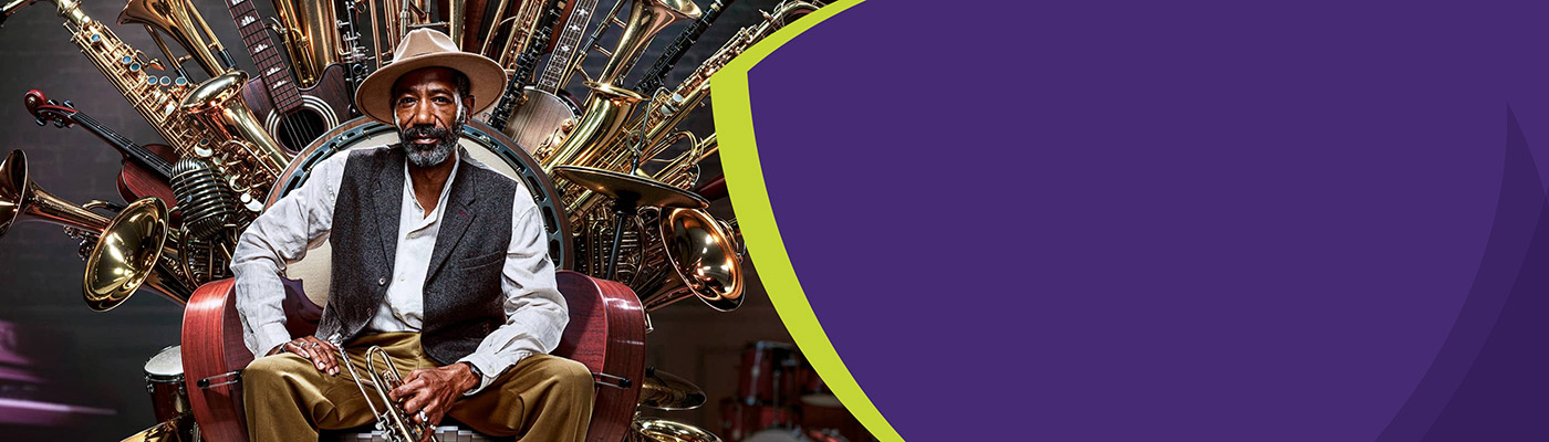 An elderly man sits confidently on a throne of various musical instruments while holding a trumpet.